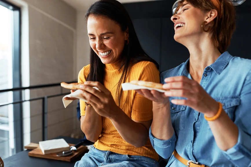 two girlfriends talking and eating pizza how to carry a conversation - digital marketing sunshine coast